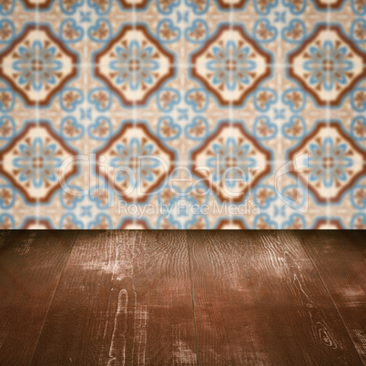 Wood table top and blur vintage ceramic tile pattern wall Wood table top and blur vintage ceramic tile pattern wall