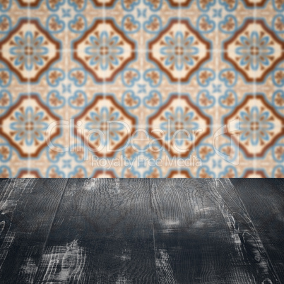 Wood table top and blur vintage ceramic tile pattern wall