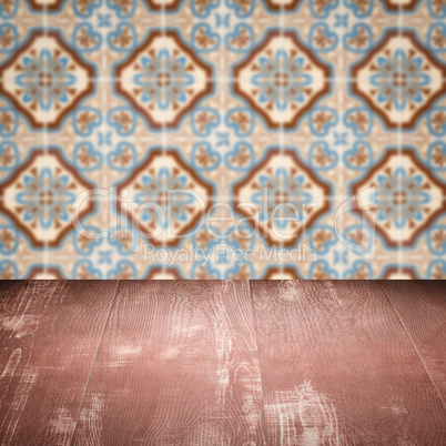 Wood table top and blur vintage ceramic tile pattern wall