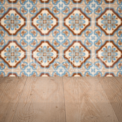 Wood table top and blur vintage ceramic tile pattern wall