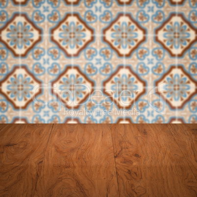 Wood table top and blur vintage ceramic tile pattern wall