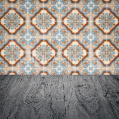 Wood table top and blur vintage ceramic tile pattern wall