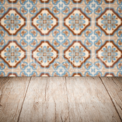 Wood table top and blur vintage ceramic tile pattern wall