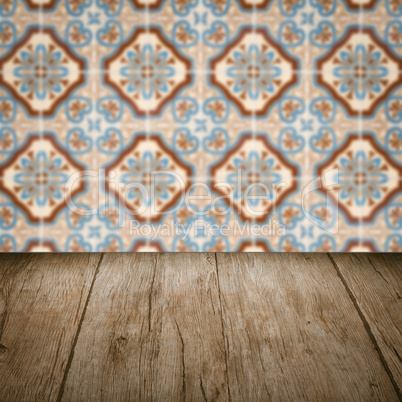 Wood table top and blur vintage ceramic tile pattern wall