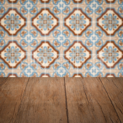 Wood table top and blur vintage ceramic tile pattern wall Wood table top and blur vintage ceramic tile pattern wall