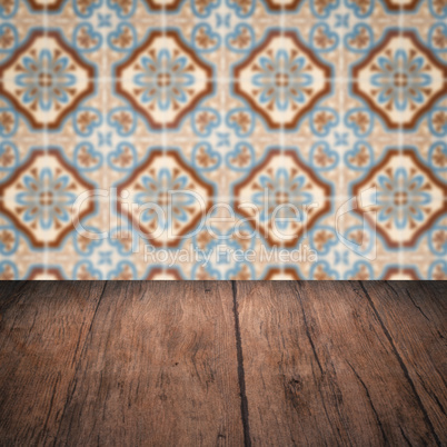 Wood table top and blur vintage ceramic tile pattern wall