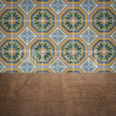 Wood table top and blur vintage ceramic tile pattern wall