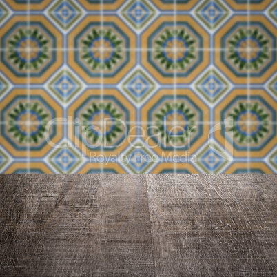 Wood table top and blur vintage ceramic tile pattern wall