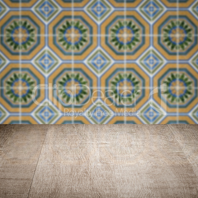 Wood table top and blur vintage ceramic tile pattern wall