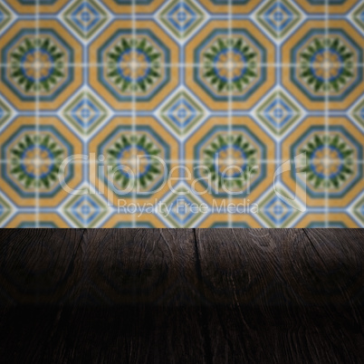 Wood table top and blur vintage ceramic tile pattern wall