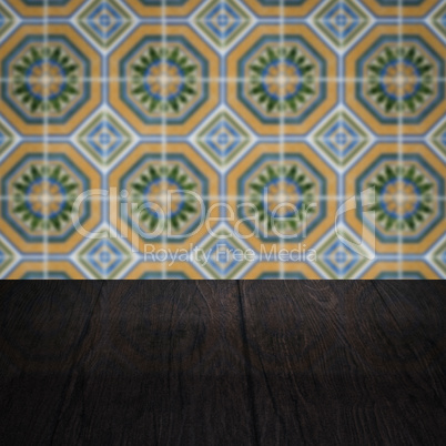 Wood table top and blur vintage ceramic tile pattern wall Wood table top and blur vintage ceramic tile pattern wall