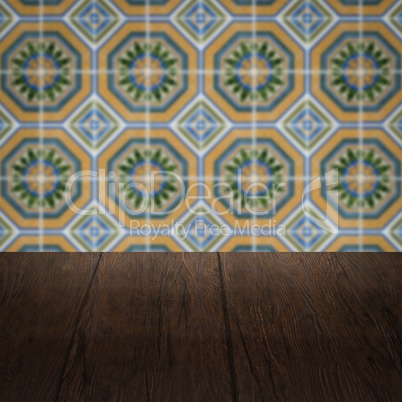 Wood table top and blur vintage ceramic tile pattern wall