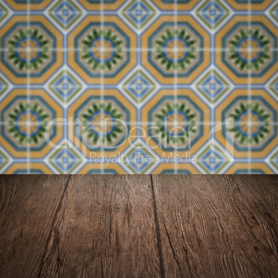 Wood table top and blur vintage ceramic tile pattern wall