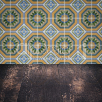 Wood table top and blur vintage ceramic tile pattern wall