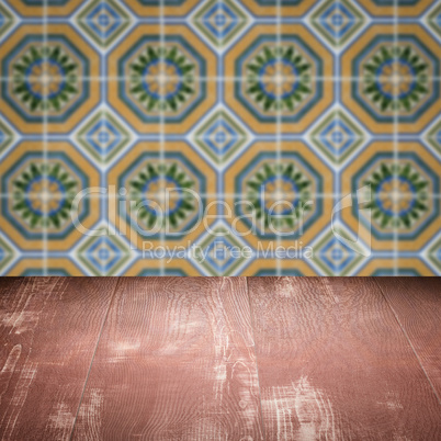 Wood table top and blur vintage ceramic tile pattern wall Wood table top and blur vintage ceramic tile pattern wall