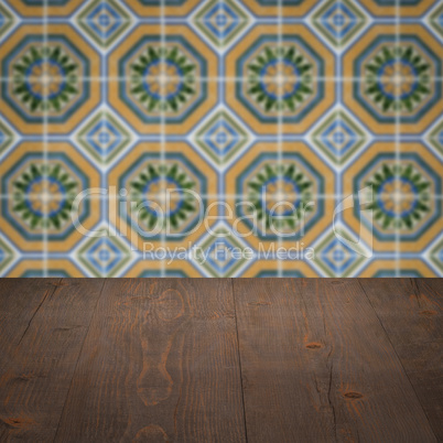 Wood table top and blur vintage ceramic tile pattern wall