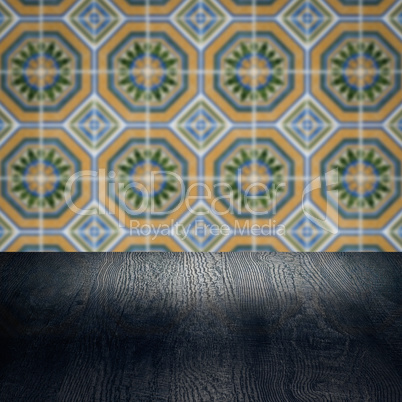 Wood table top and blur vintage ceramic tile pattern wall