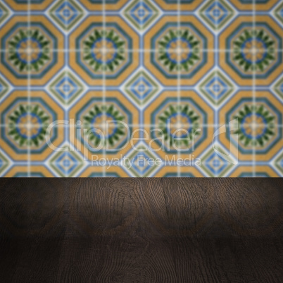 Wood table top and blur vintage ceramic tile pattern wall