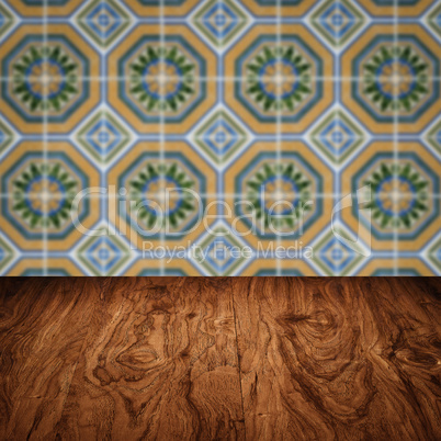 Wood table top and blur vintage ceramic tile pattern wall Wood table top and blur vintage ceramic tile pattern wall