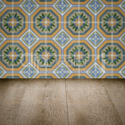 Wood table top and blur vintage ceramic tile pattern wall