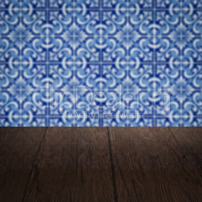 Wood table top and blur vintage ceramic tile pattern wall