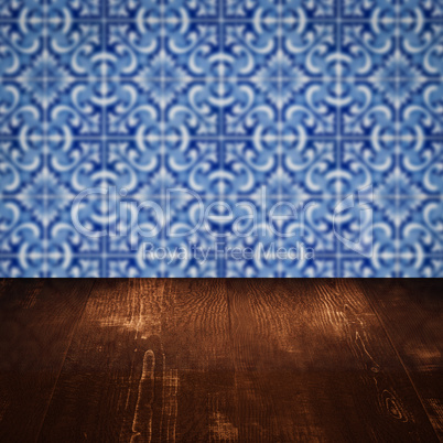 Wood table top and blur vintage ceramic tile pattern wall