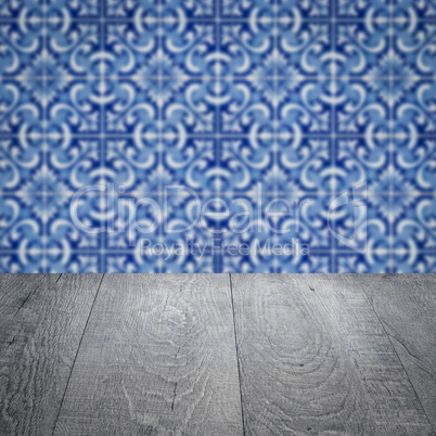Wood table top and blur vintage ceramic tile pattern wall Wood table top and blur vintage ceramic tile pattern wall