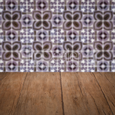 Wood table top and blur vintage ceramic tile pattern wall