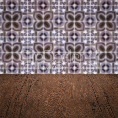 Wood table top and blur vintage ceramic tile pattern wall