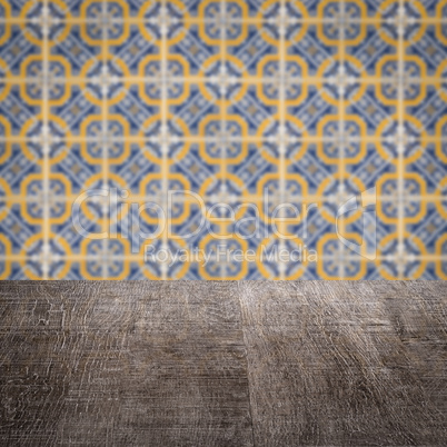 Wood table top and blur vintage ceramic tile pattern wall