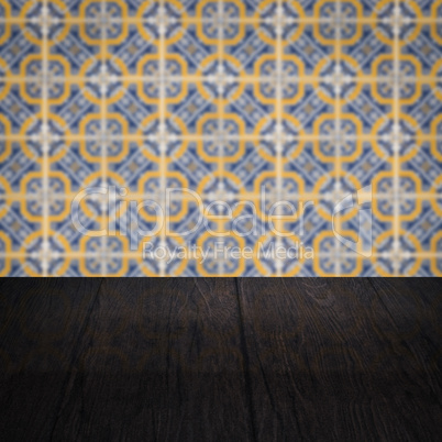 Wood table top and blur vintage ceramic tile pattern wall