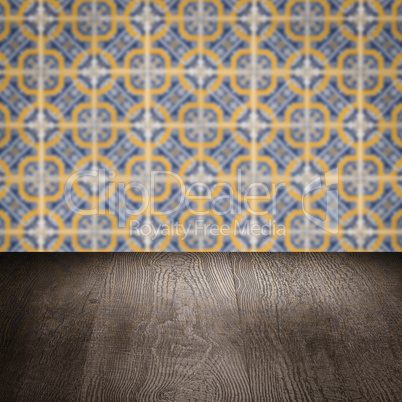 Wood table top and blur vintage ceramic tile pattern wall