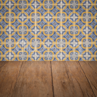 Wood table top and blur vintage ceramic tile pattern wall