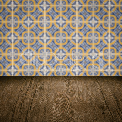 Wood table top and blur vintage ceramic tile pattern wall