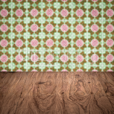 Wood table top and blur vintage ceramic tile pattern wall