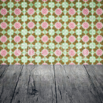 Wood table top and blur vintage ceramic tile pattern wall Wood table top and blur vintage ceramic tile pattern wall
