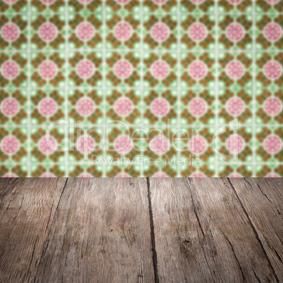 Wood table top and blur vintage ceramic tile pattern wall Wood table top and blur vintage ceramic tile pattern wall