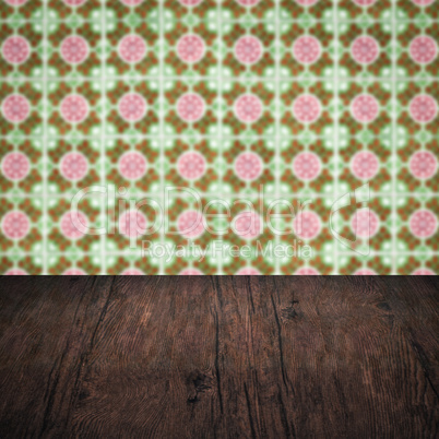 Wood table top and blur vintage ceramic tile pattern wall