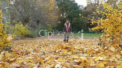 woman is kicking autumn leaves