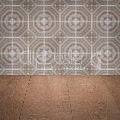 Wood table top and blur vintage ceramic tile pattern wall