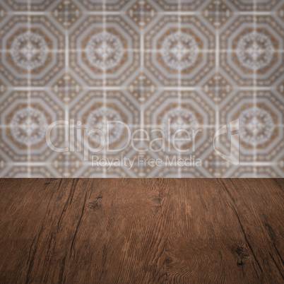 Wood table top and blur vintage ceramic tile pattern wall