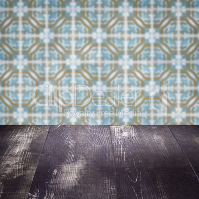 Wood table top and blur vintage ceramic tile pattern wall