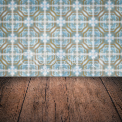 Wood table top and blur vintage ceramic tile pattern wall