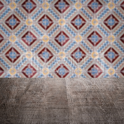 Wood table top and blur vintage ceramic tile pattern wall