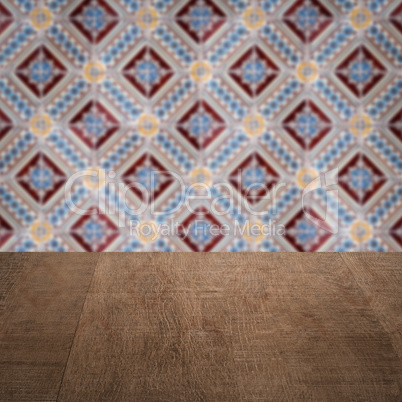Wood table top and blur vintage ceramic tile pattern wall Wood table top and blur vintage ceramic tile pattern wall