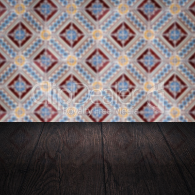 Wood table top and blur vintage ceramic tile pattern wall