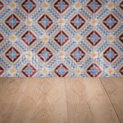 Wood table top and blur vintage ceramic tile pattern wall