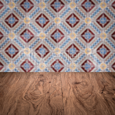 Wood table top and blur vintage ceramic tile pattern wall