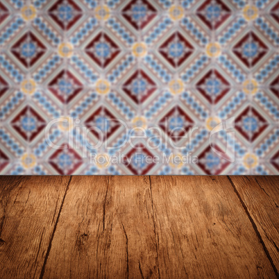 Wood table top and blur vintage ceramic tile pattern wall