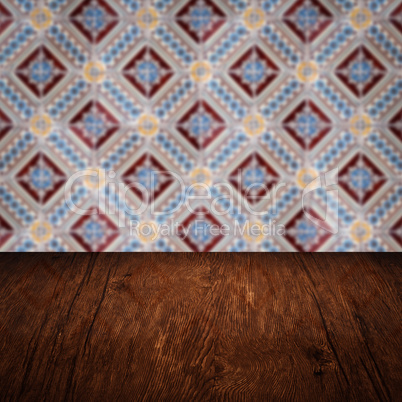 Wood table top and blur vintage ceramic tile pattern wall